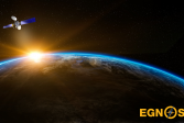 Maapallo avaruudesta kuvattuna. Sen takaa näkyy auringon säteitä ja sen yläpuolella on satelliitti. Oikeassa alakulmassa lukee EGNOS.