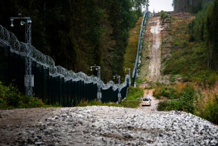 The barrier fence consists of a metal mesh fence, an adjacent road, a treeless area and a technical monitoring system.